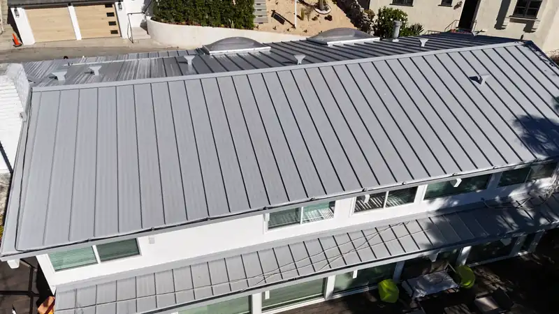 Silver standing seam roof with evenly spaced raised seams and no exposed fasteners